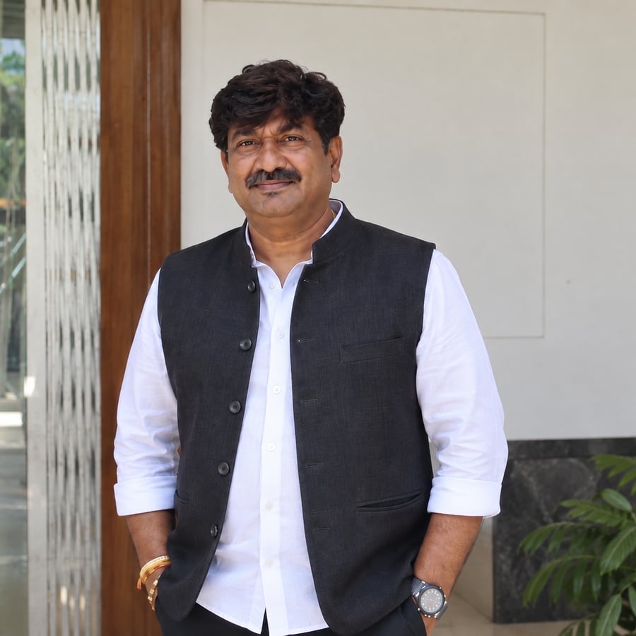 Portrait of Ramesh BV in a white shirt and dark Nehru vest